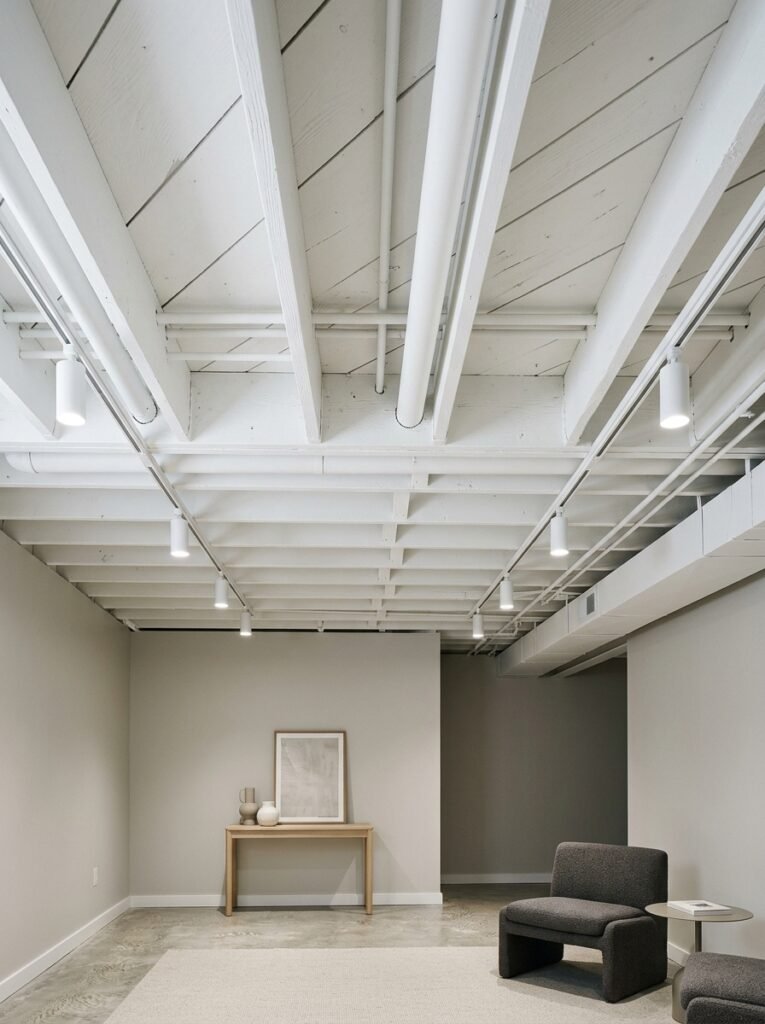 Whitewashed exposed joists on a basement ceiling